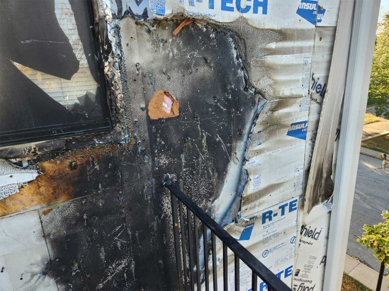 A building that has been damaged by a fire with a staircase in front of it.