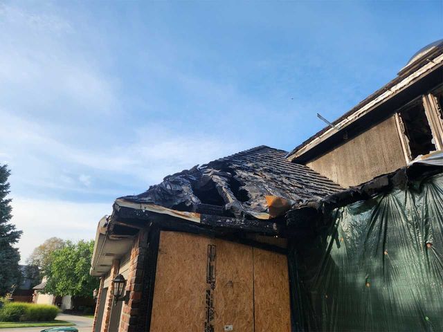 A house with a roof that has been damaged by a fire.