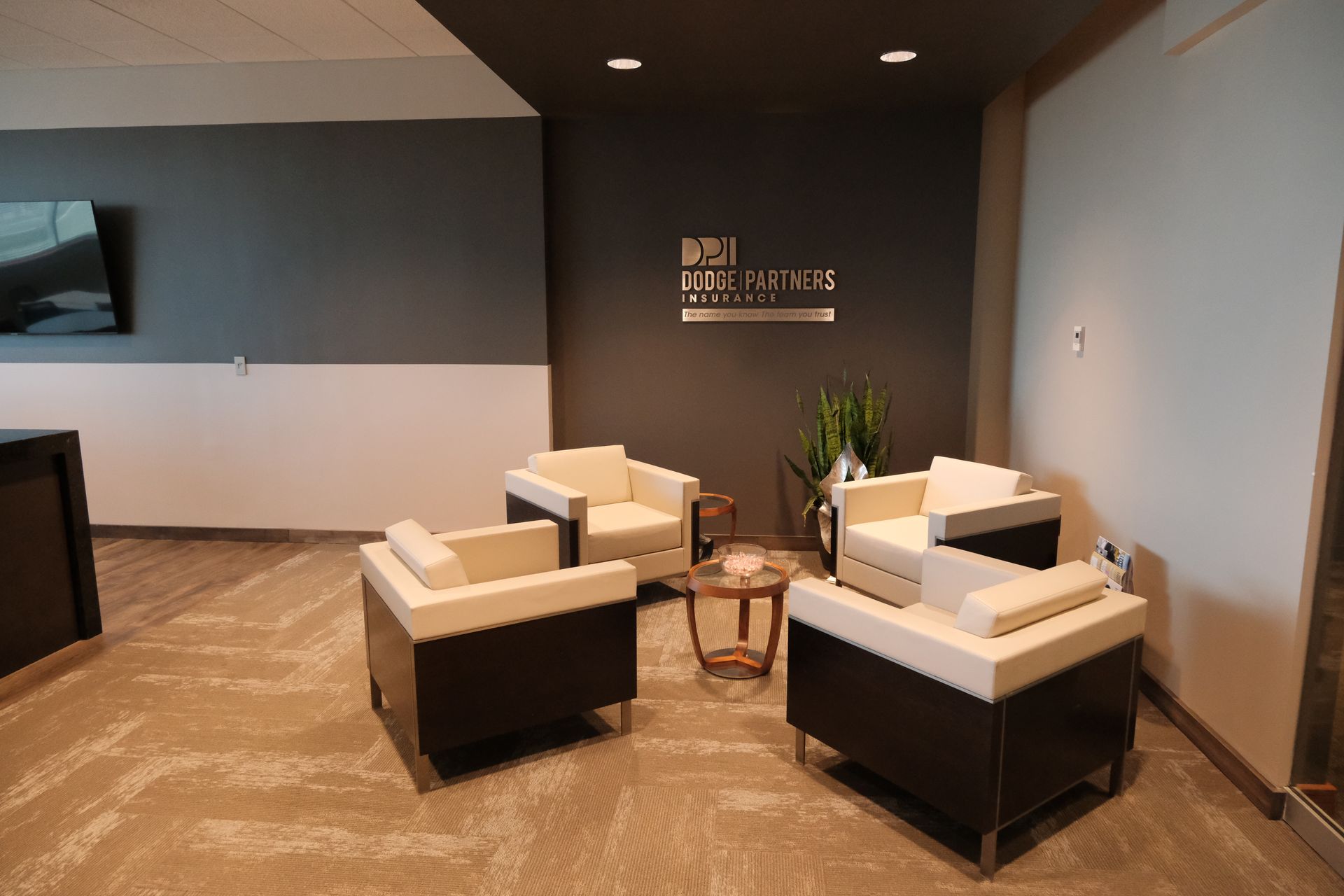 A waiting room with chairs and a table with a sign on the wall that says news