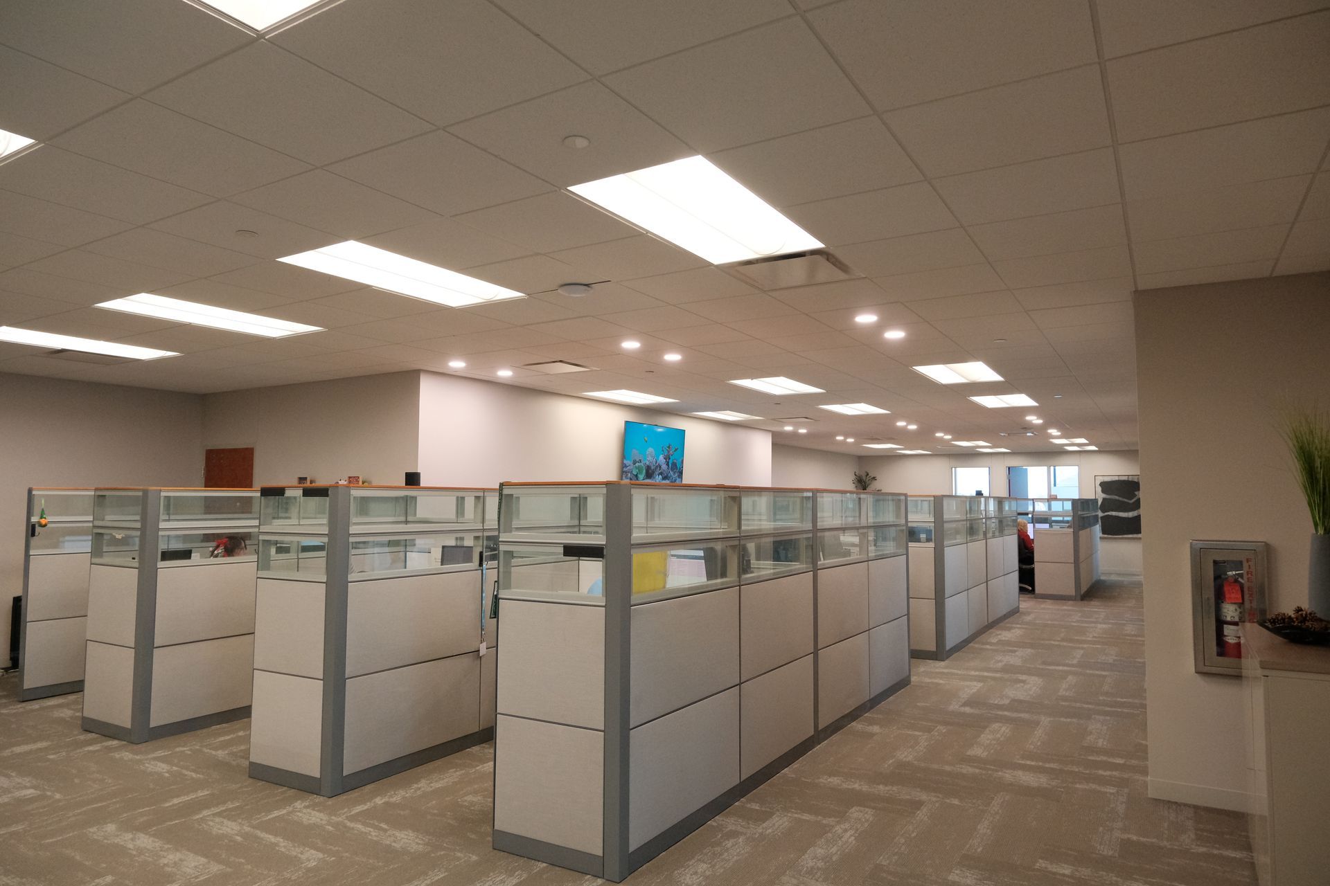 A large office with cubicles and a fire extinguisher