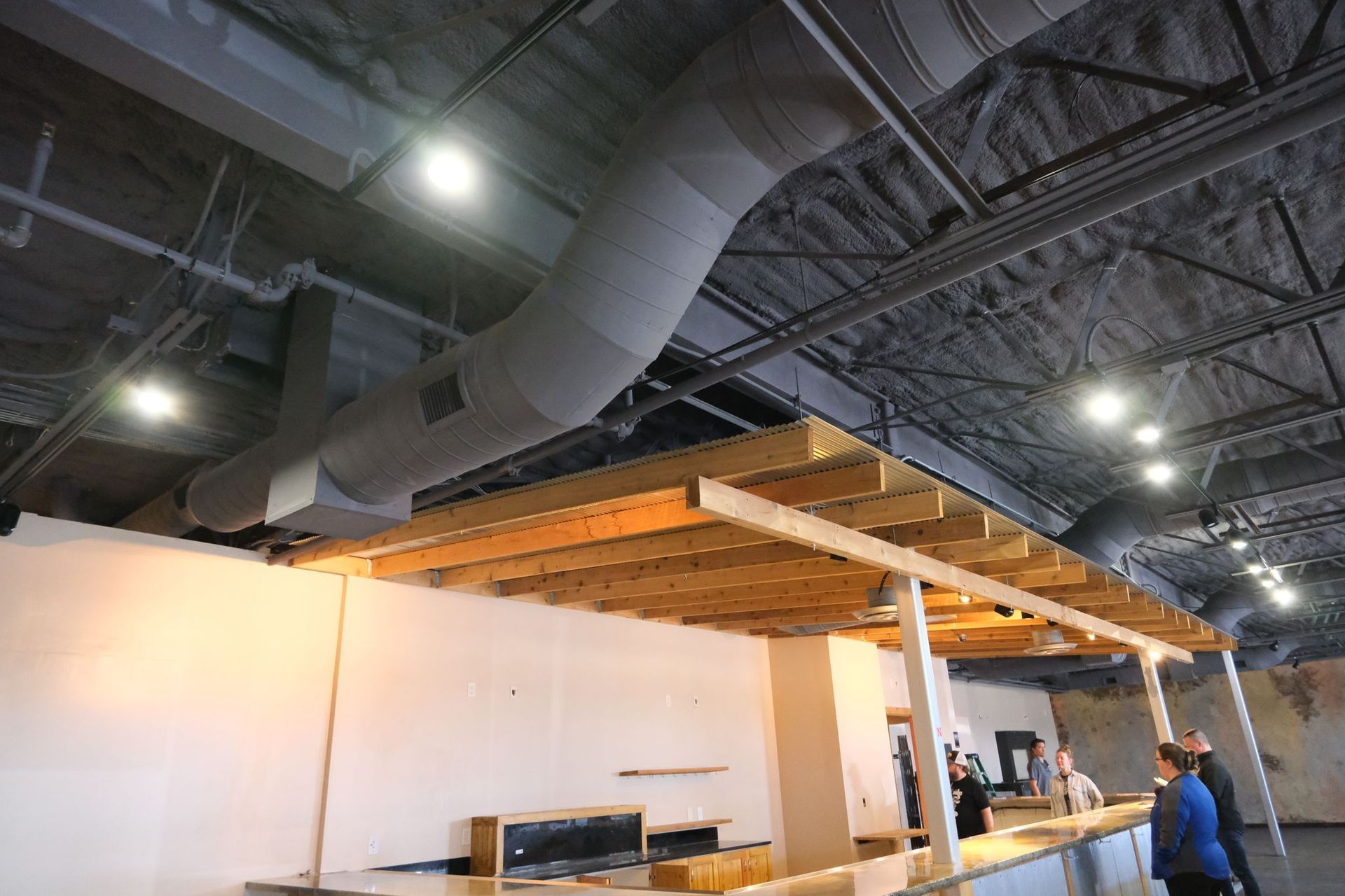 Construction site with ductwork, wooden beams, and a partially built structure.