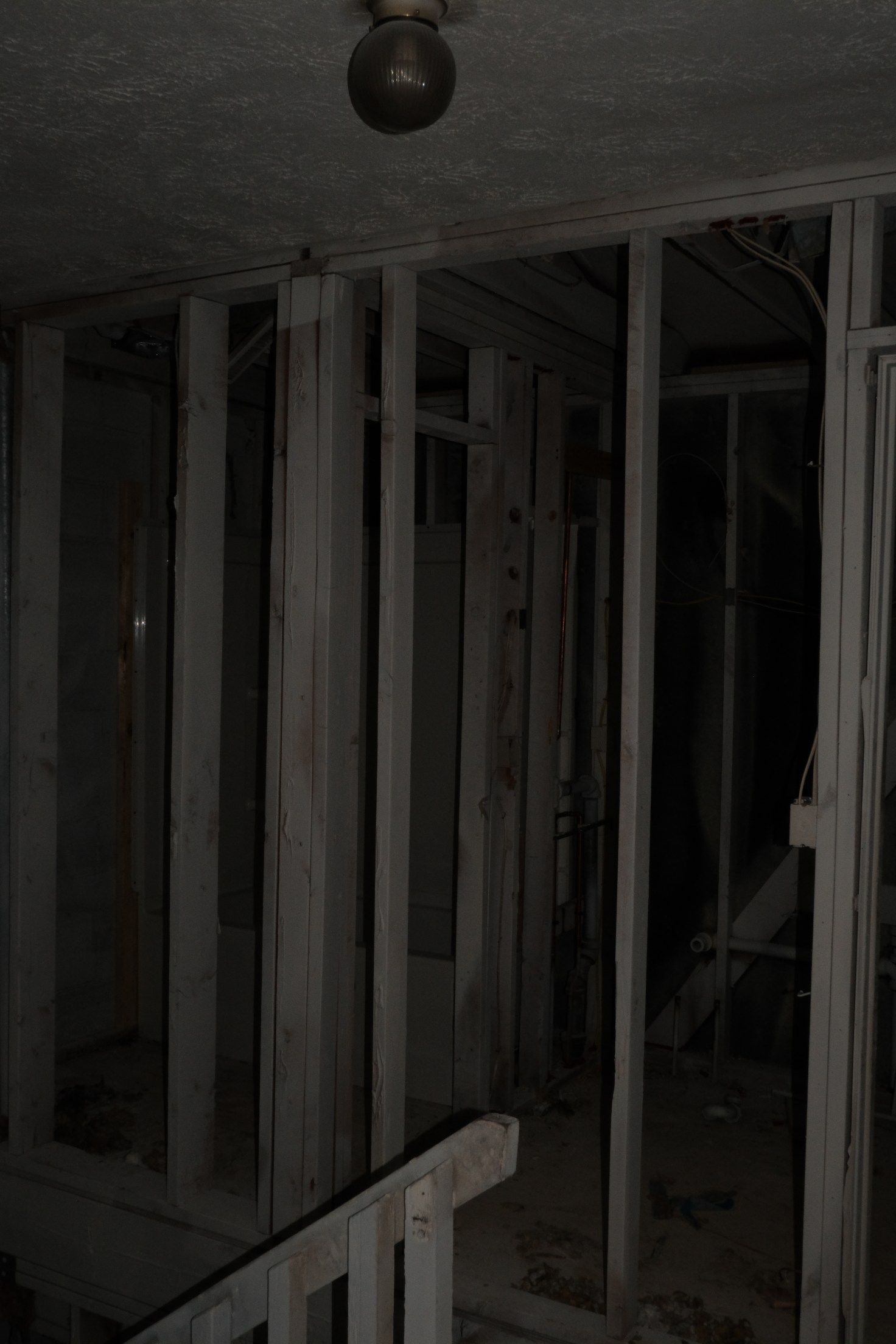 Old, dark room with exposed wooden beams. Dim light from a single bulb.