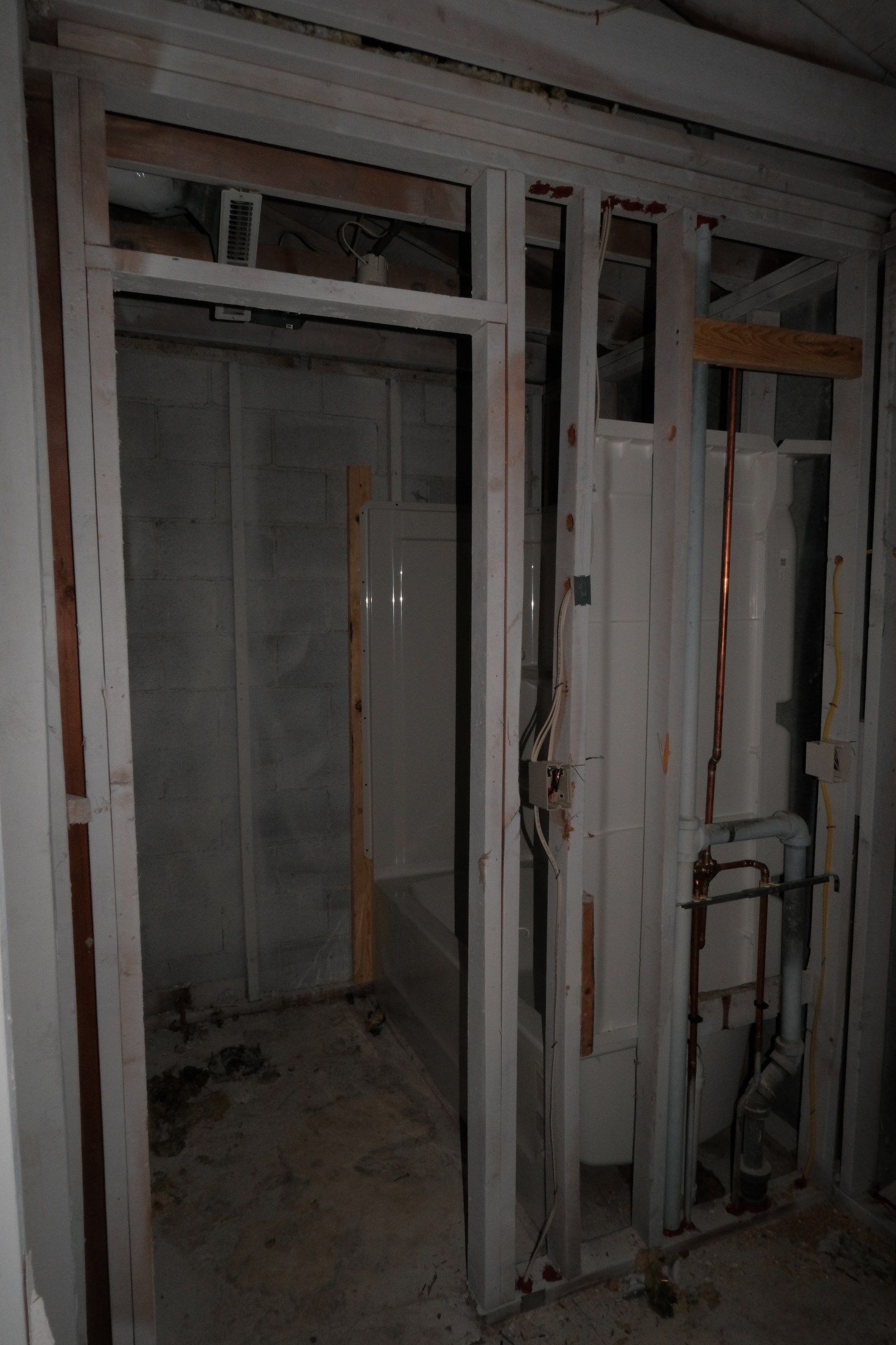 Interior room framing with doorway, plumbing, and partial walls.