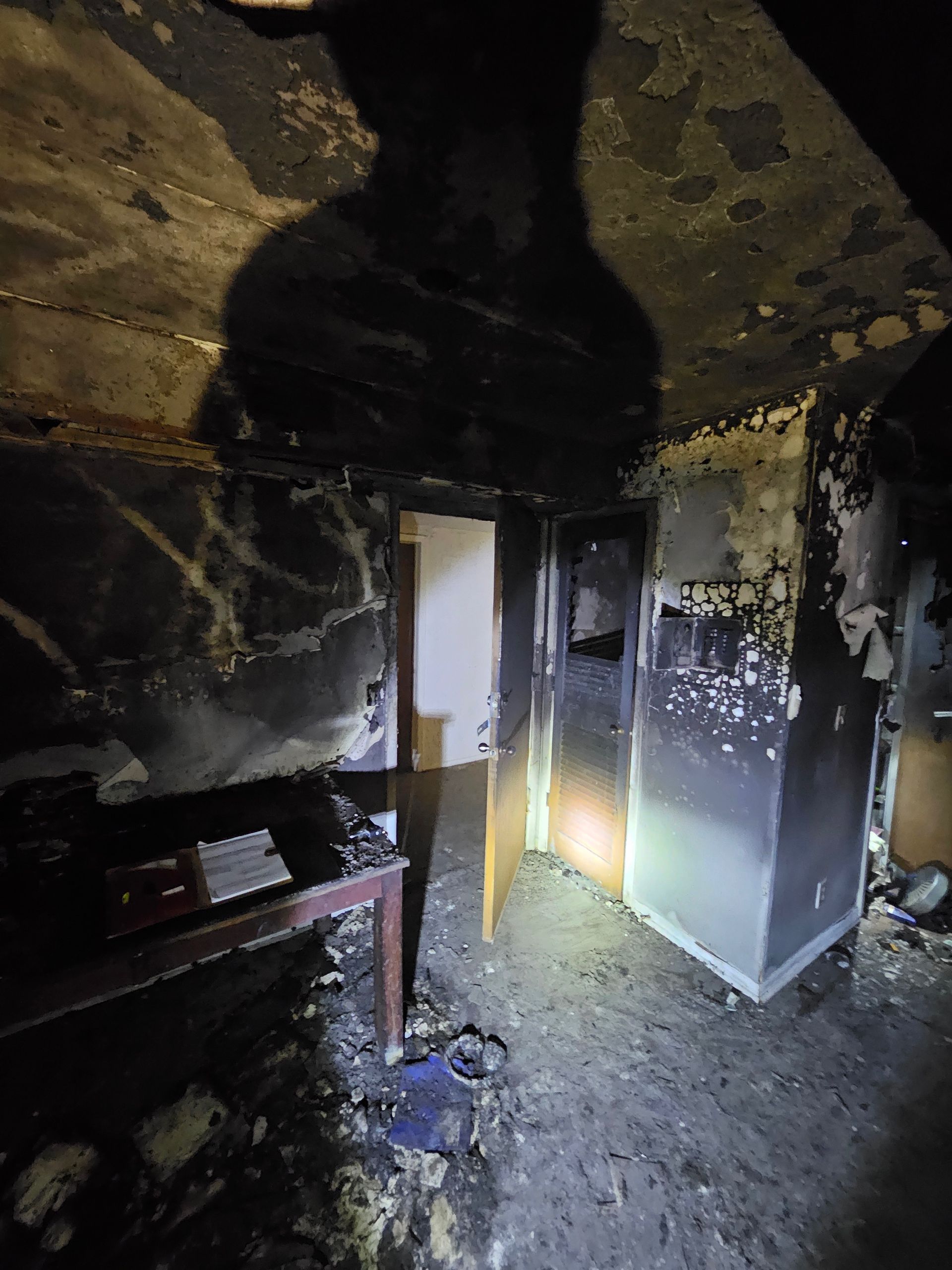 A dark room with a shadow of a person on the ceiling.