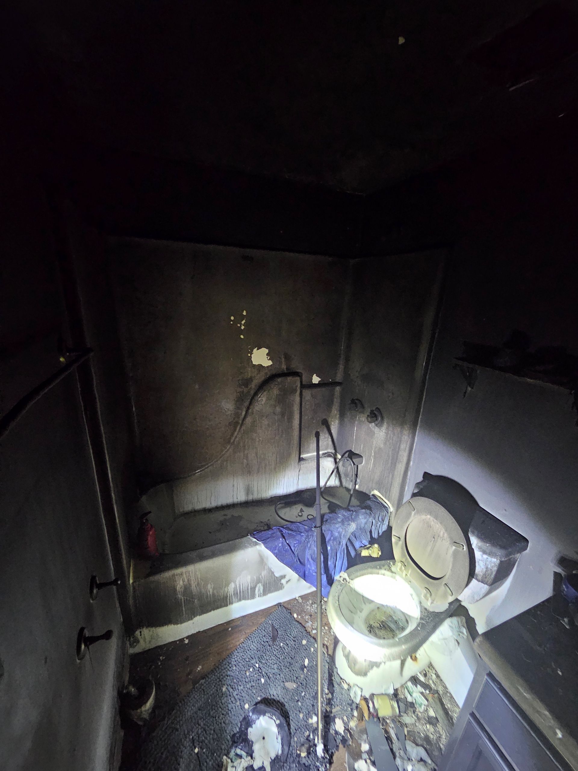 A bathroom with a toilet , bathtub and shower.