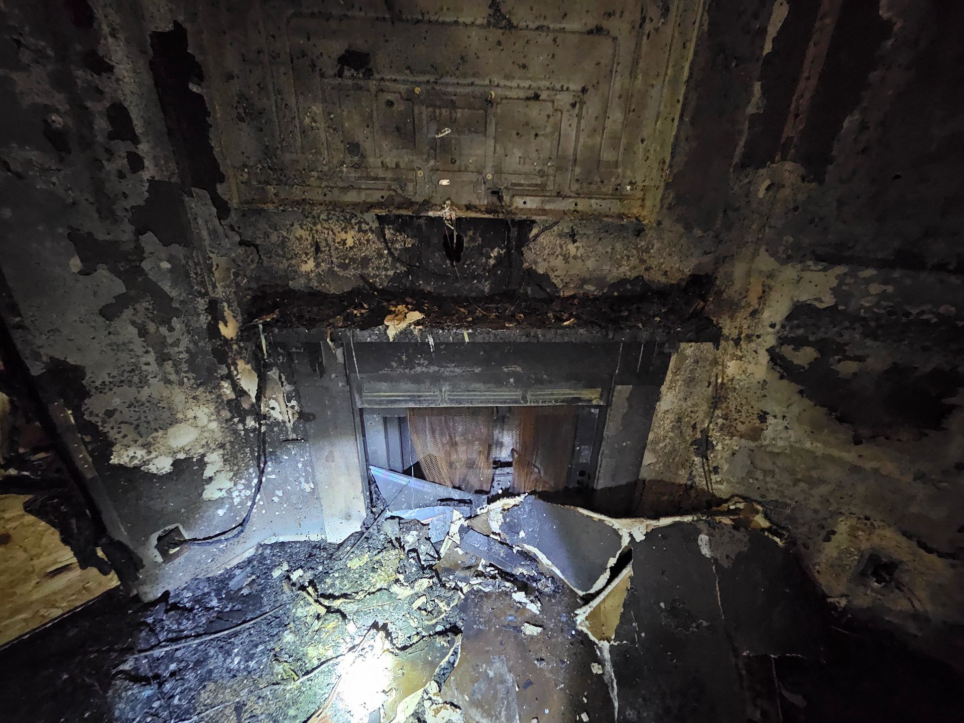 A dark room with a fireplace in the middle of it