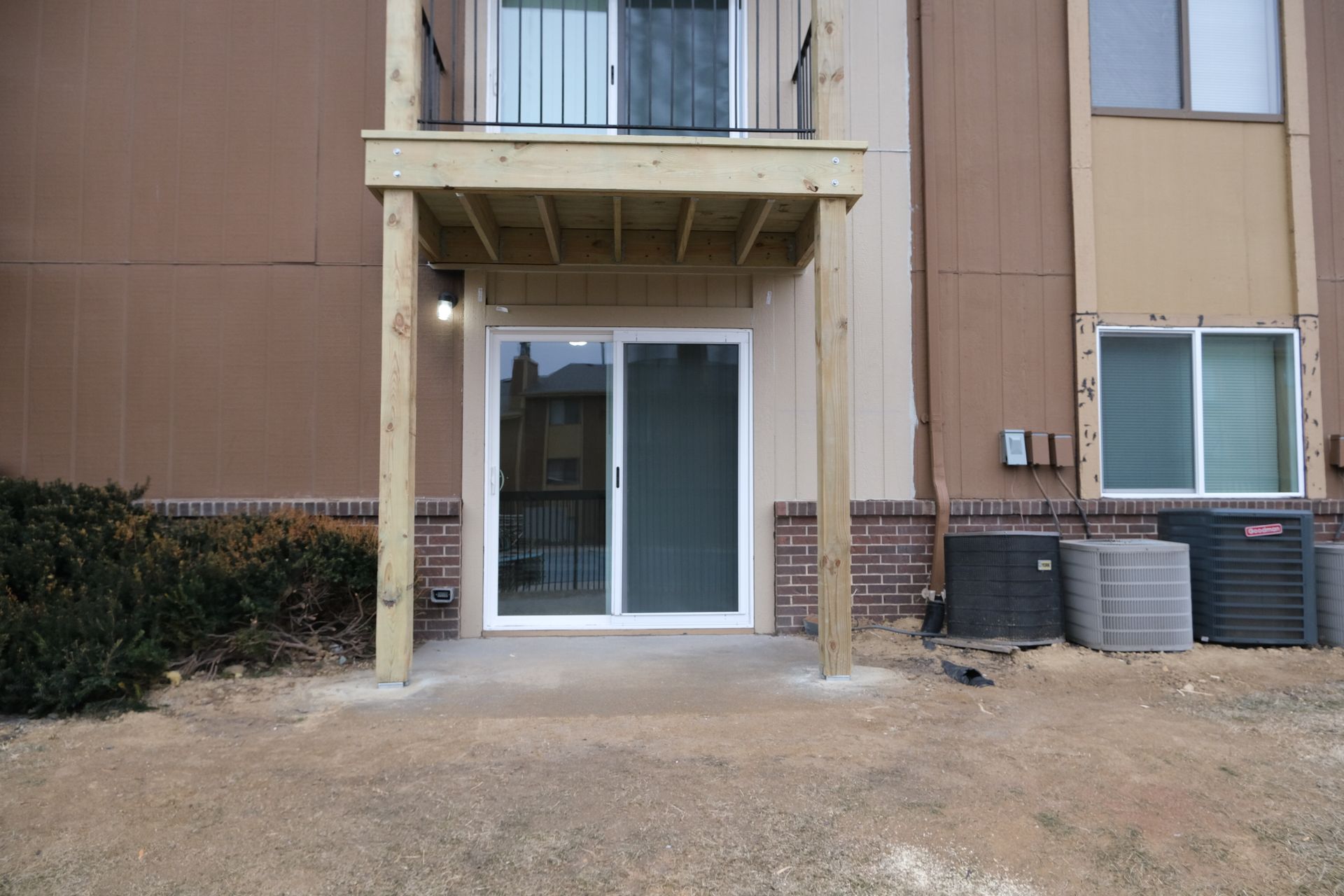 A building with a deck and sliding glass doors