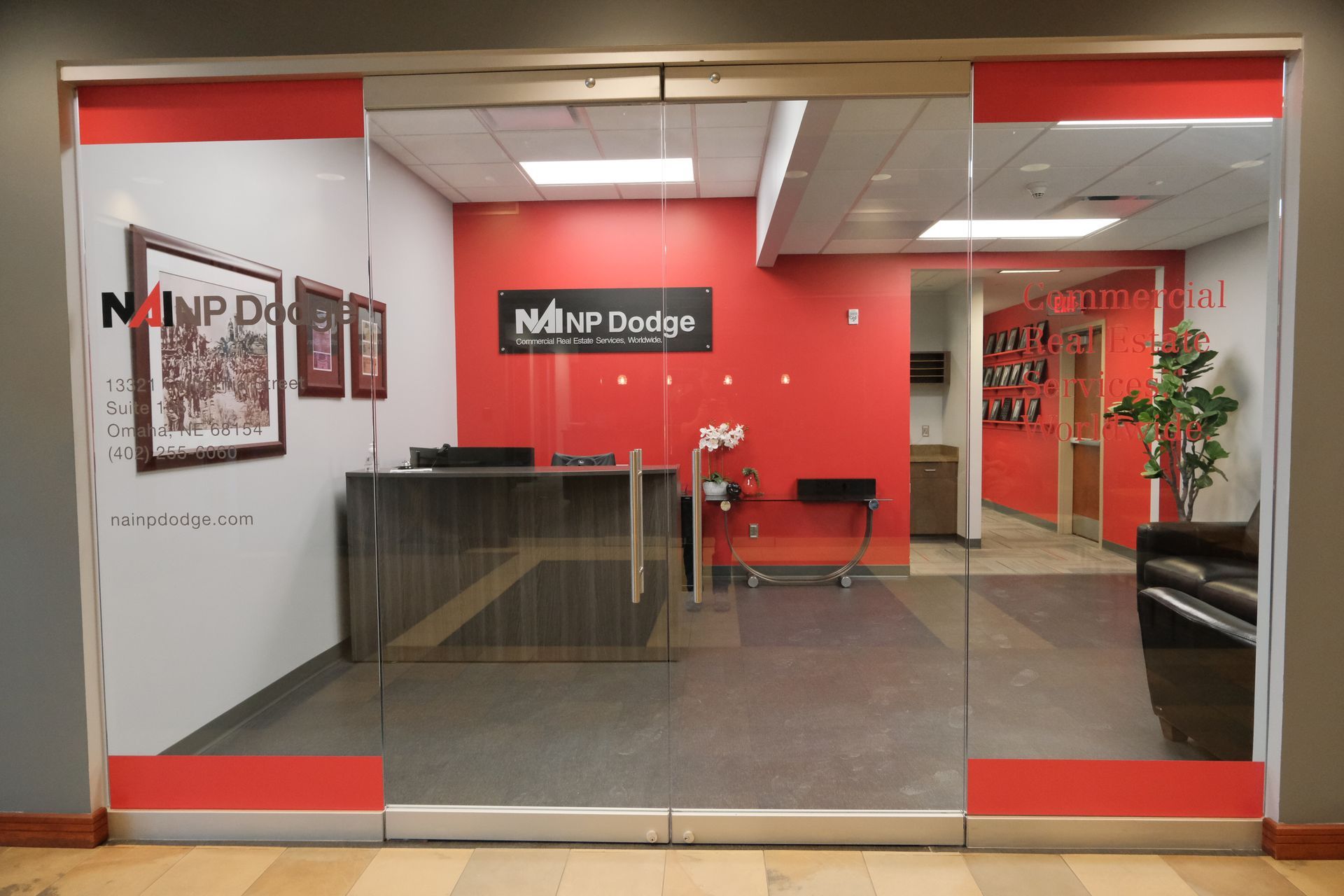 A reception area with a glass door and a sign that says nanp dodge