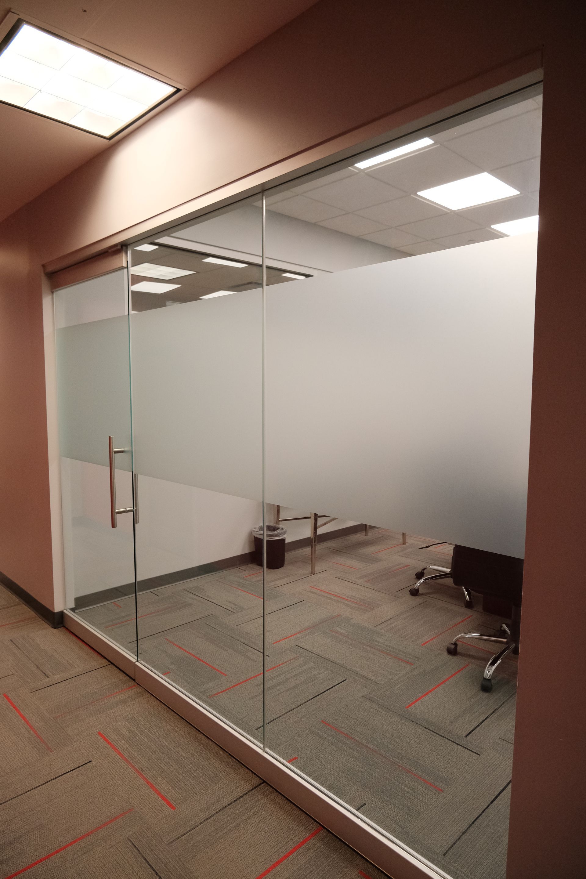 A room with a glass wall and a chair in it.