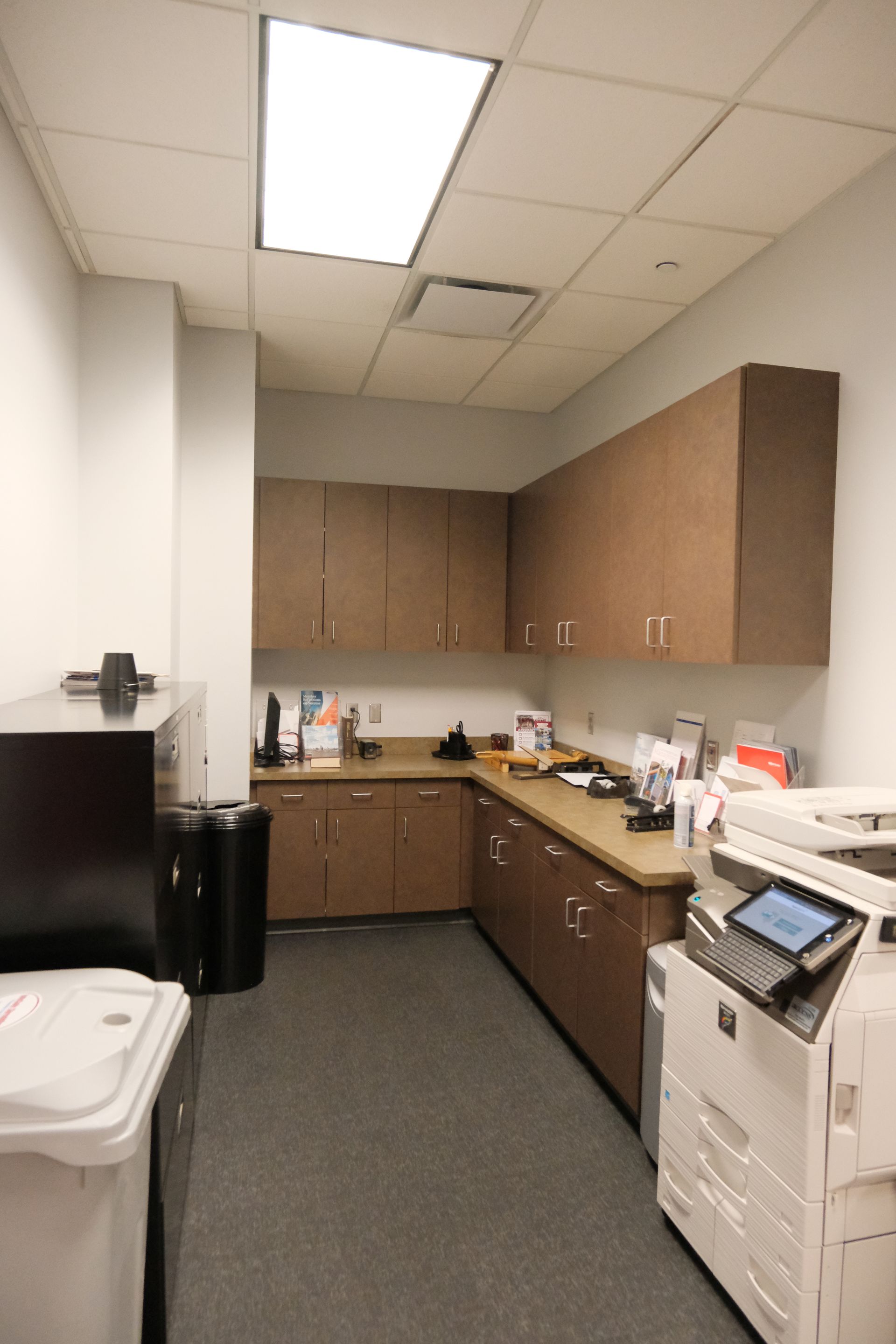 A kitchen with brown cabinets and a white printer