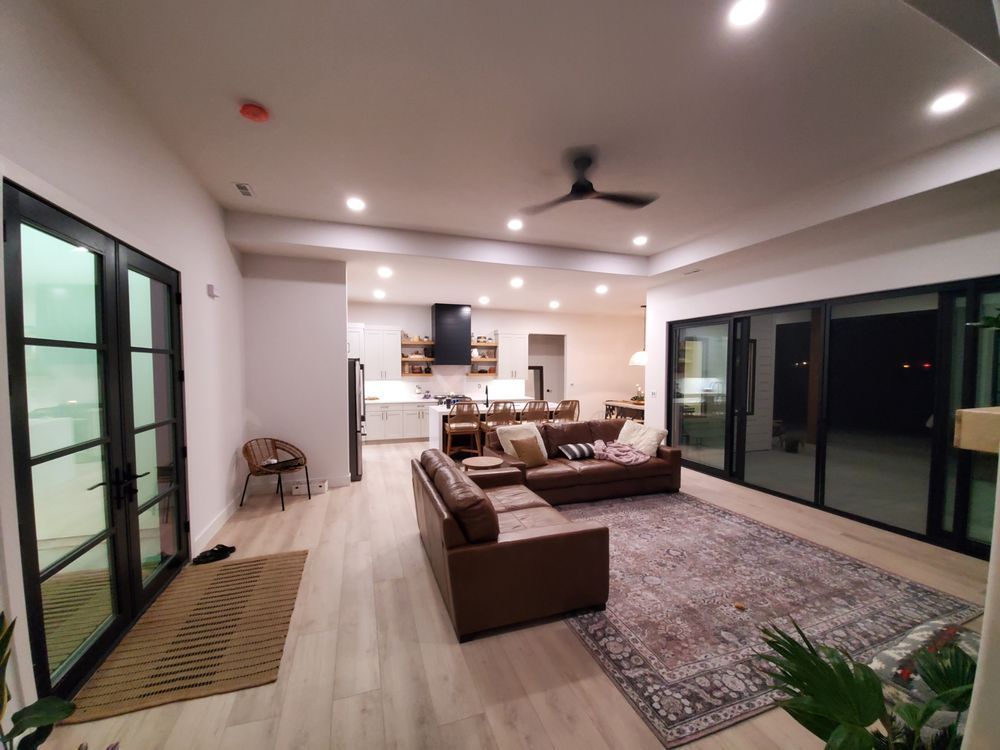 A living room with a couch and a rug and a ceiling fan