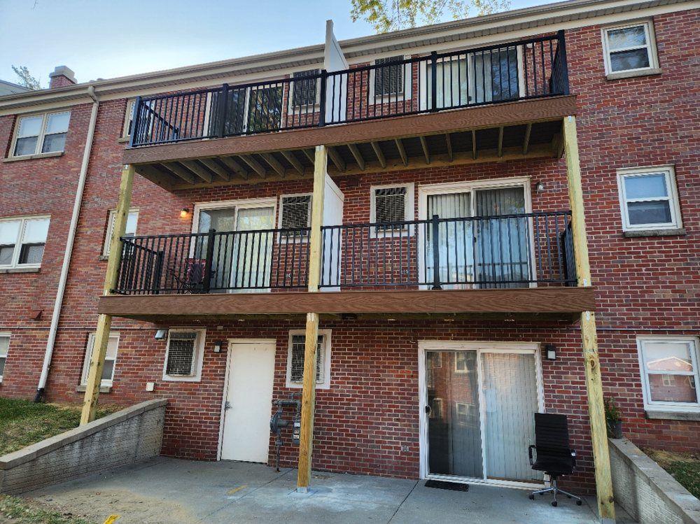 A brick building with a balcony and a sliding glass door.