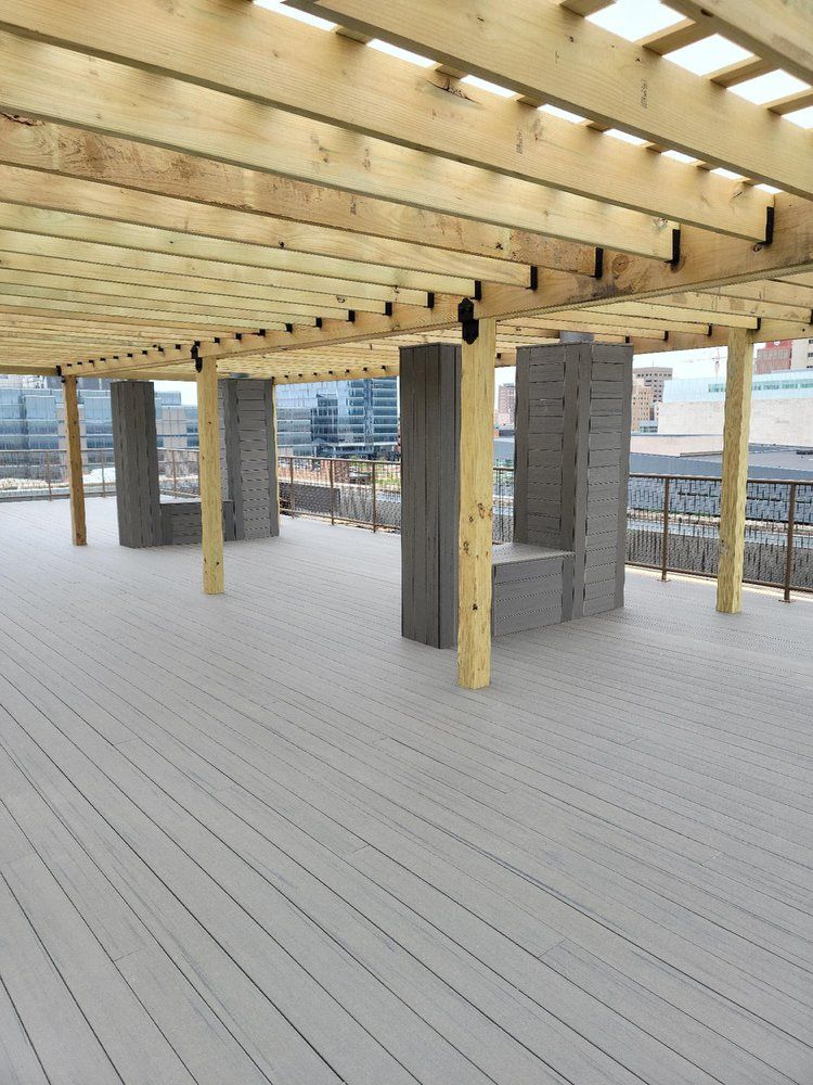 A large deck with a wooden roof and pillars