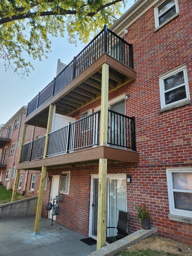 A brick building with a balcony on the second floor.