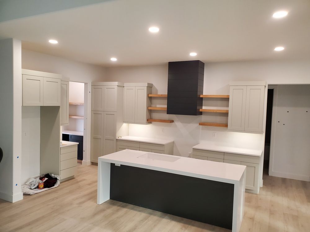 A kitchen with white cabinets and a large island in the middle.