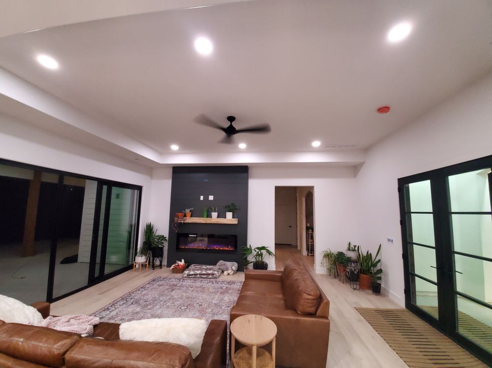 A living room with a brown couch and a ceiling fan