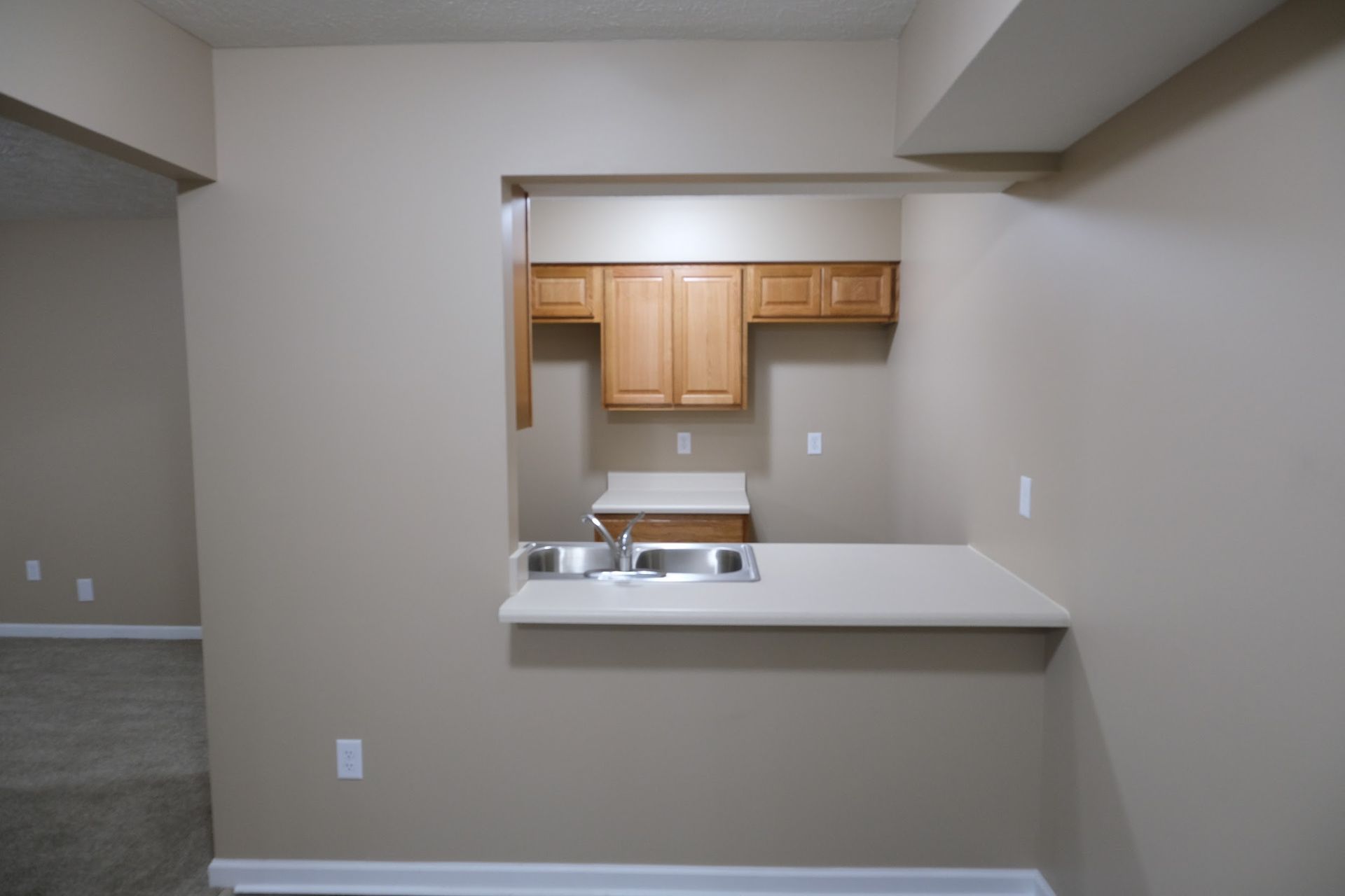 An empty kitchen with a sink and cabinets
