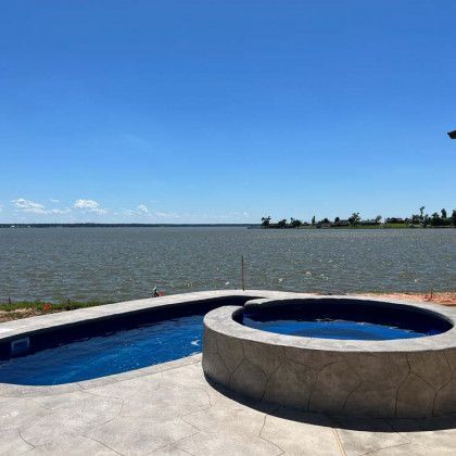 A large swimming pool is surrounded by a large body of water.