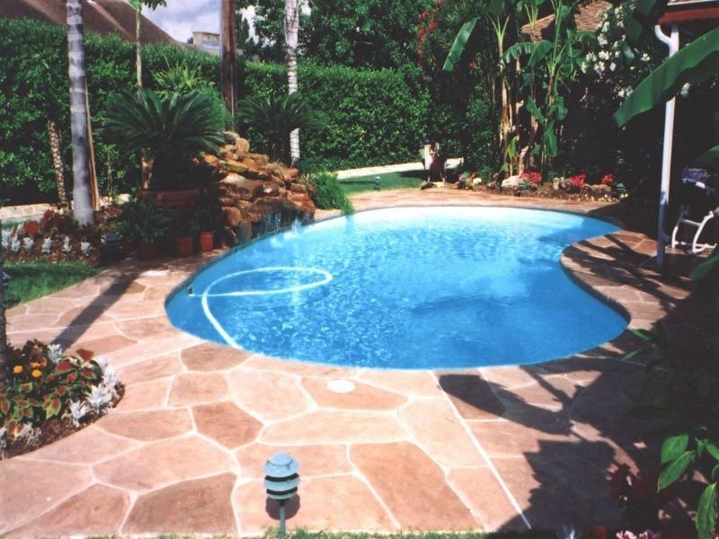 A large swimming pool in the backyard of a house