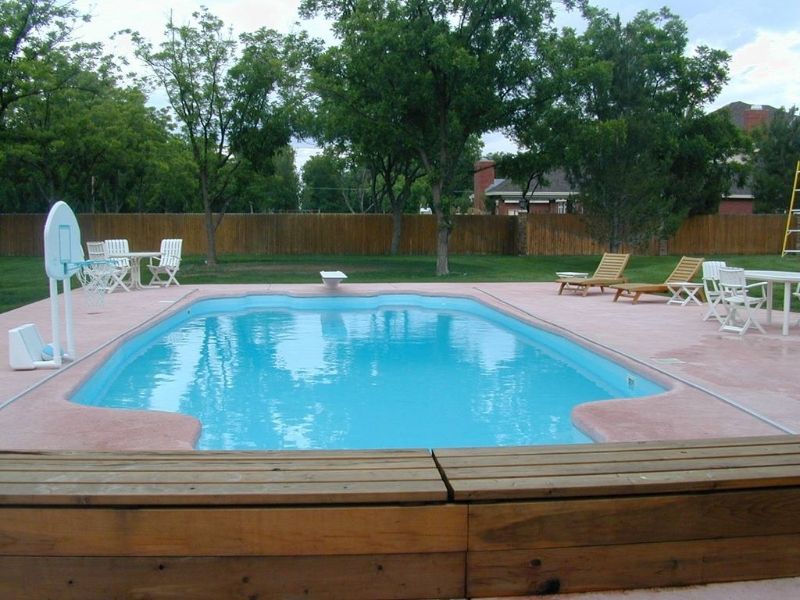 A large swimming pool surrounded by chairs and tables