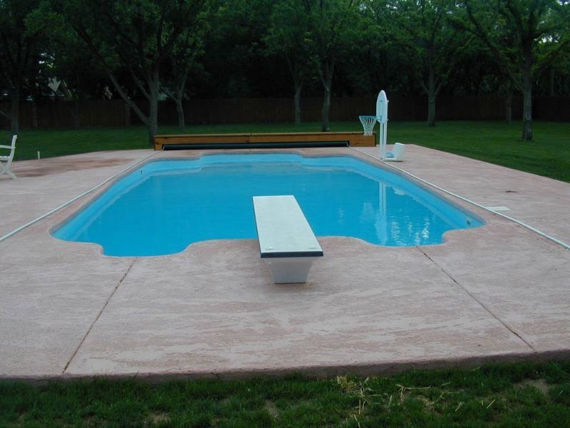 A swimming pool with a diving board in the middle