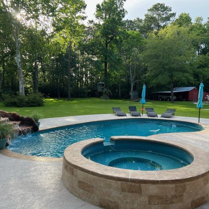 A large swimming pool with a hot tub in the middle