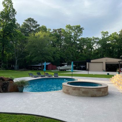 A large swimming pool with a hot tub in the backyard of a house.