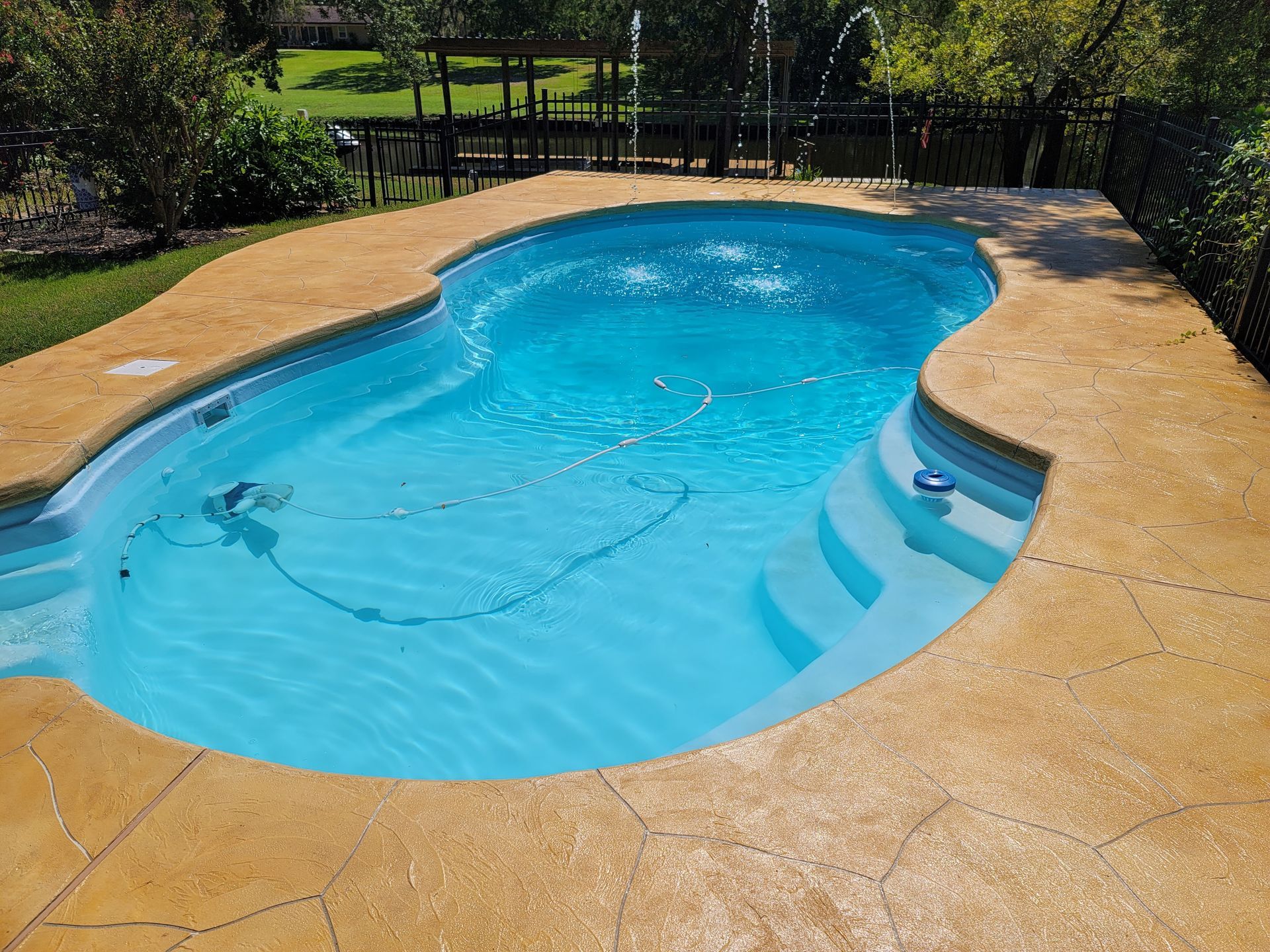 A large blue swimming pool with stairs leading to it.