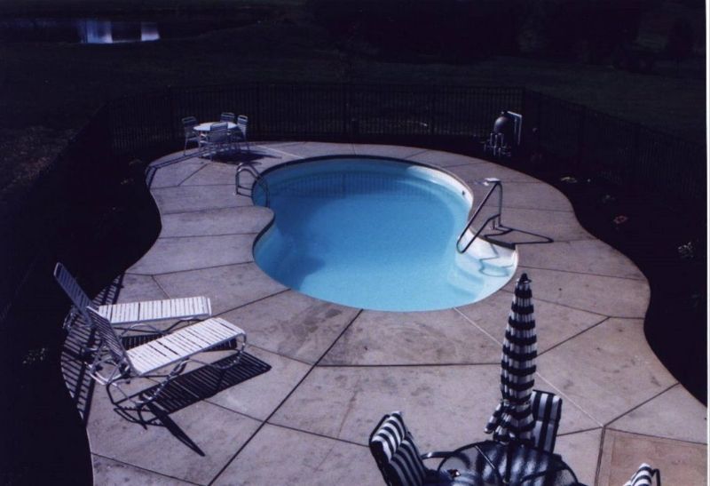 A swimming pool with chairs and umbrellas around it
