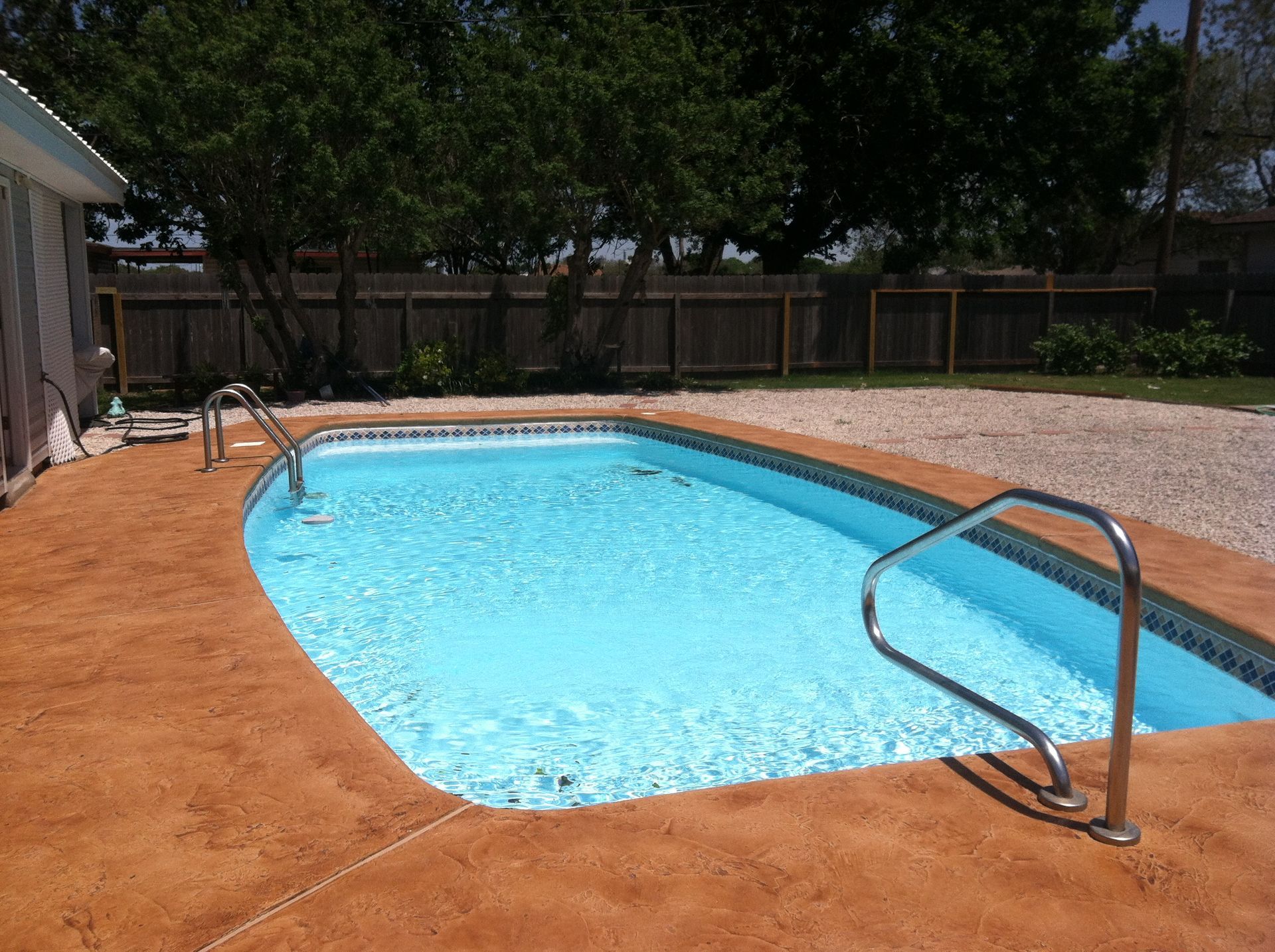 A large swimming pool with a fence in the background
