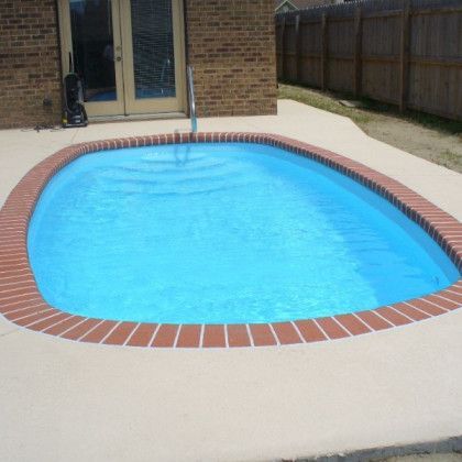 A small swimming pool with a red brick border