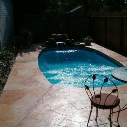 A swimming pool with a table and chairs in front of it