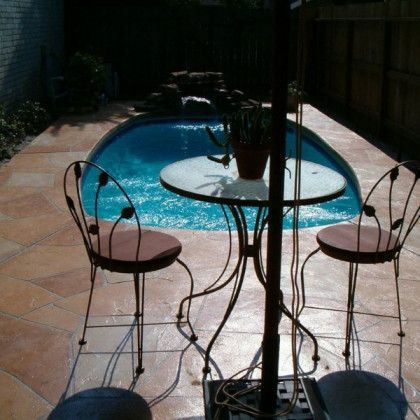 A table and chairs in front of a swimming pool