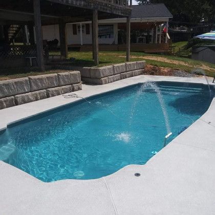 A large swimming pool with a fountain in the middle of it
