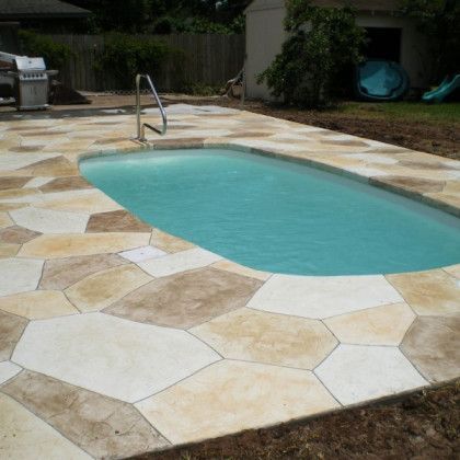 A large swimming pool surrounded by a tiled patio