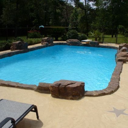 A large swimming pool surrounded by rocks and trees