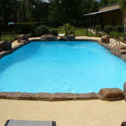 A large swimming pool with a house in the background