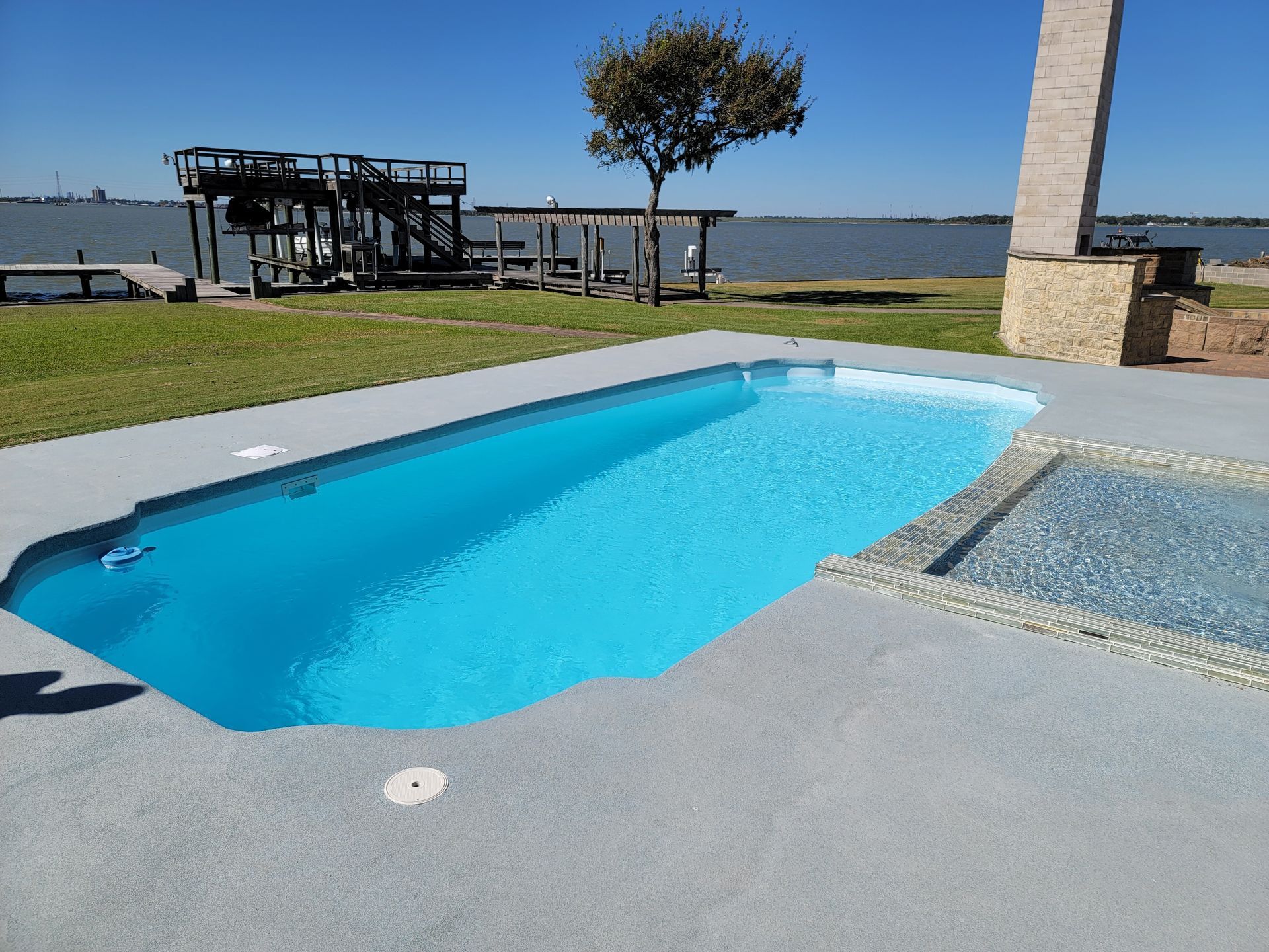 A large swimming pool with a thatched hut in the background