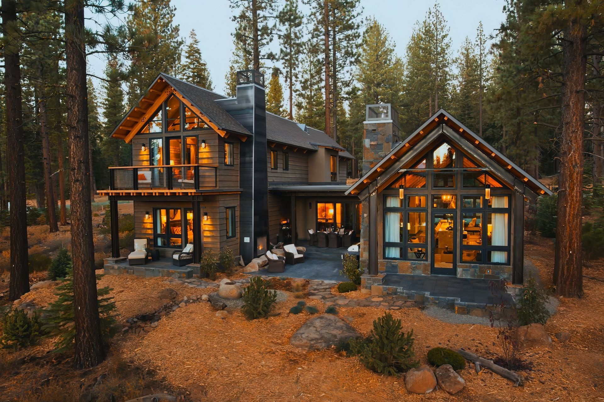 Suburban house with stone exterior, front porch, and white picket fence at dusk