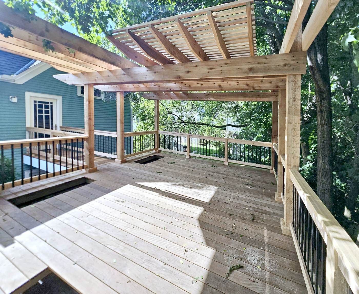 Roof deck with Ipe decking, cedar posts and railings, and an angled cedar pergola overhead.