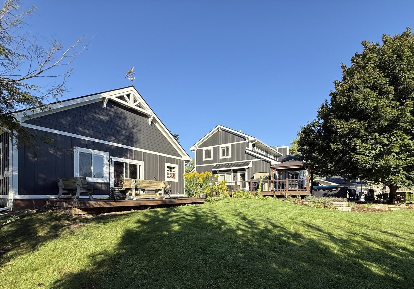 Detached garage with matching board and batten siding and a white cedar truss in the gable.