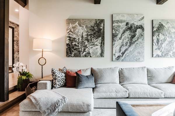 Bright living room with light gray sectional, floor lamp, and abstract wall art