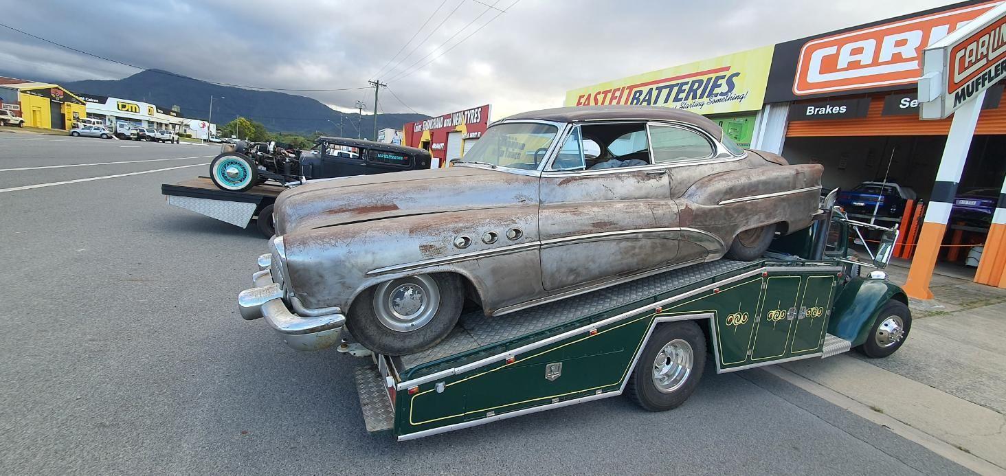 An Old Car Is Being Towed by A Tow Truck — Carline Automotive Solutions in Bungalow, QLD