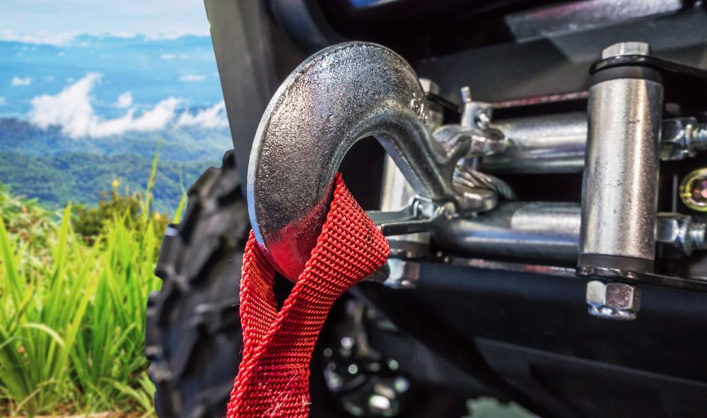 A Close up Of a Winch Hook on A Vehicle with A Red Rope Attached to It — Carline Automotive Solutions in Bungalow, QLD