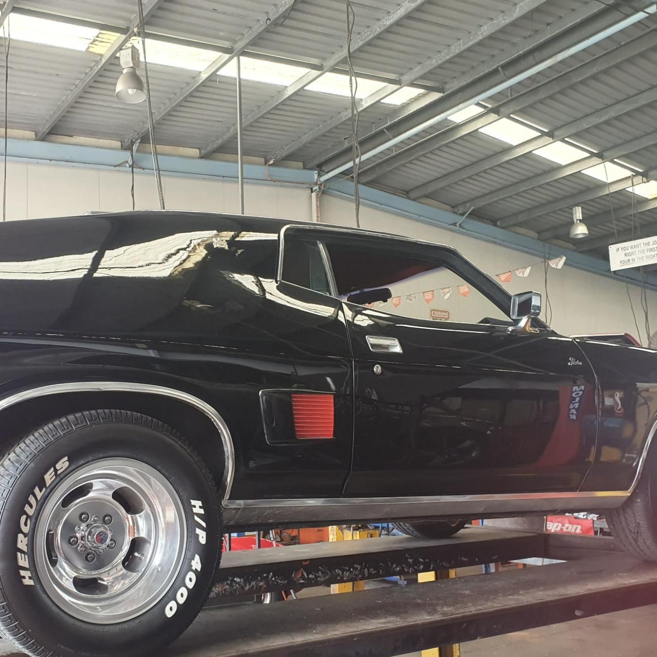 A Black Car Is Parked in A Garage — Carline Automotive Solutions in Bungalow, QLD