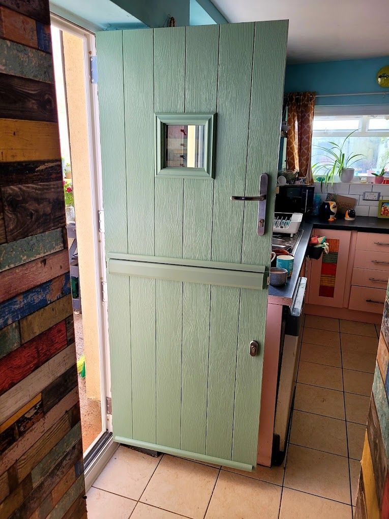 Mint-green textured door with a small square window in a narrow kitchen doorway