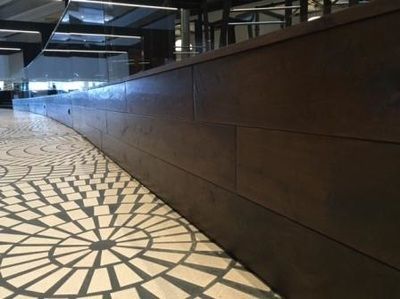 There is a circular pattern on the floor and a wooden wall.