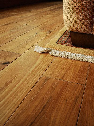 A wooden floor with a rug on it in a living room.