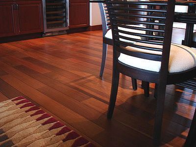A dining room with a table and chairs and a rug on the floor