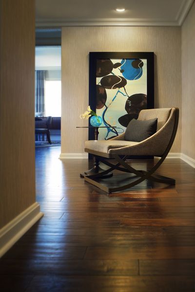 A living room with a chair and a painting on the wall